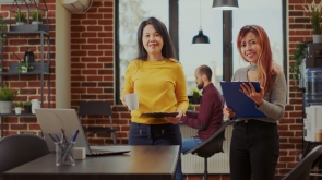 Portrait of asian business women meeting in company office, working together on e marketing and briefing about paperwork. Startup colleagues wirh clipboard planning work collaboration.